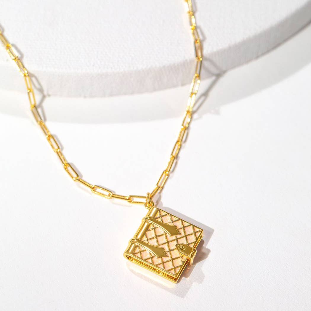 Gold necklace with a locket pendant on a white background