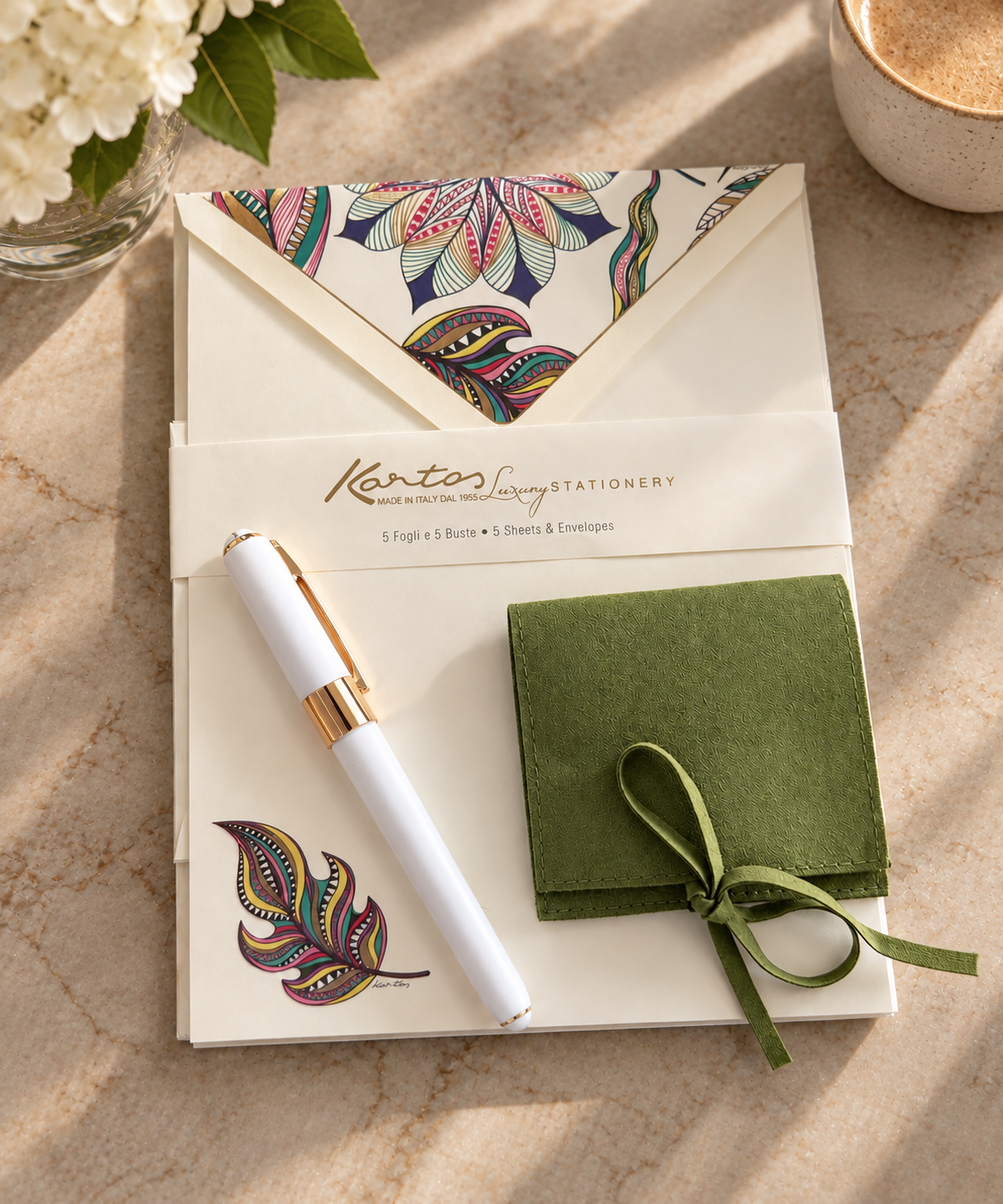 Italian floral stationery set with patterned envelope, white and gold pen, and green ribbon-bound notebook