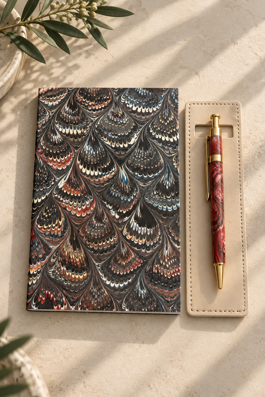 Marbled journal with a red floral pen and leather pen holder
