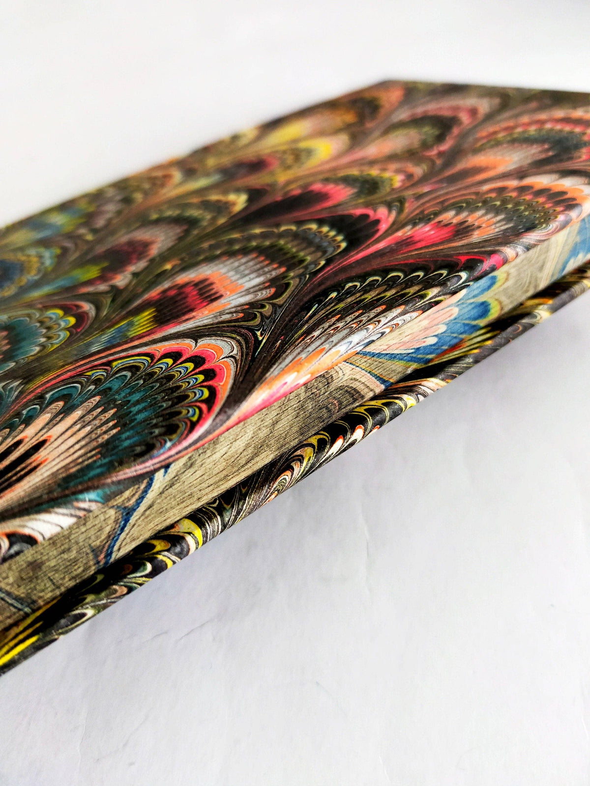 Detailed view of a colorful marbled journal cover and patterned page edges